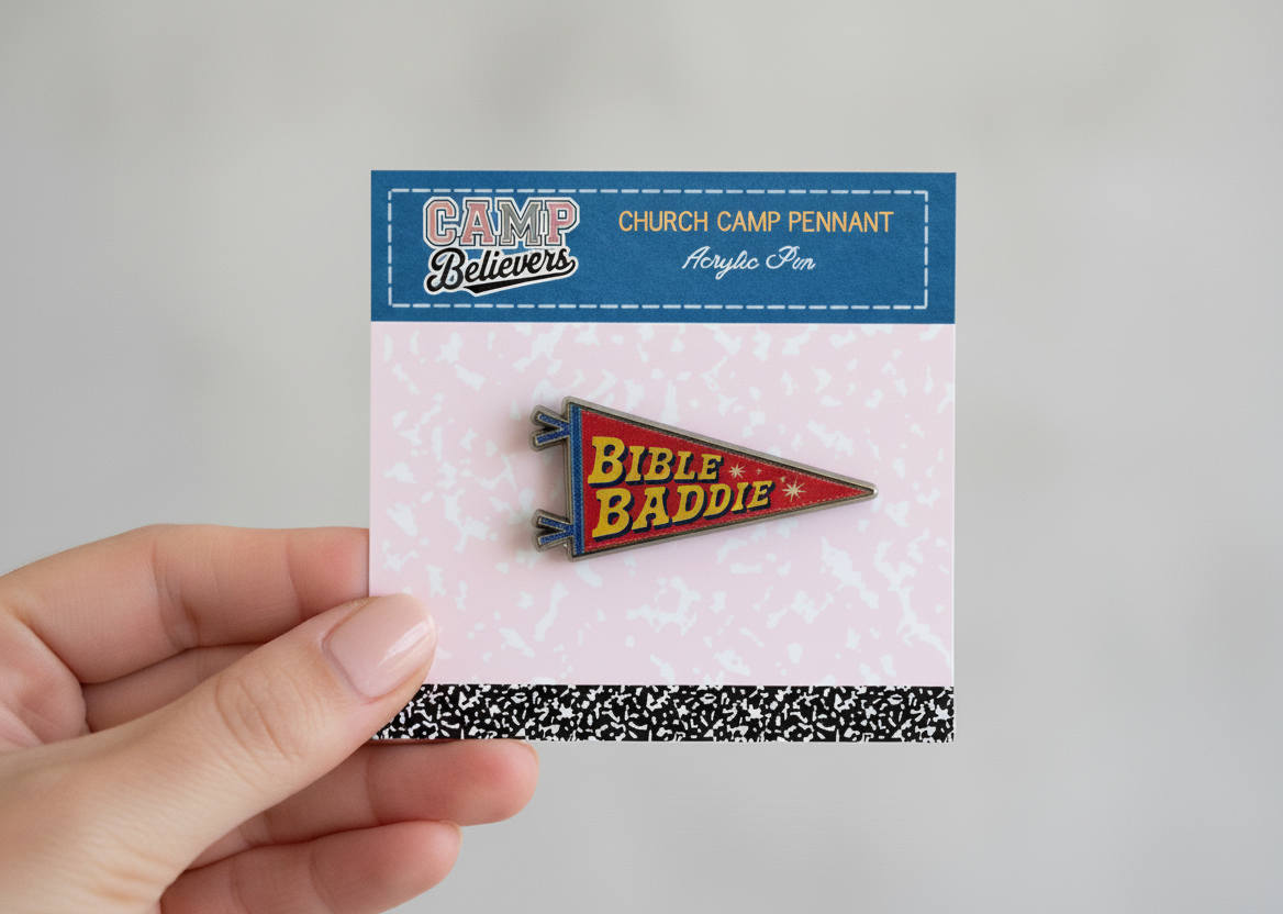 Hand holding a 'Bible Baddie' pennant pin with packaging labeled 'Camp Believers'.
