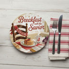 Decorative plate with 'Breakfast with the Savior' design on a wooden table with cutlery and napkin.