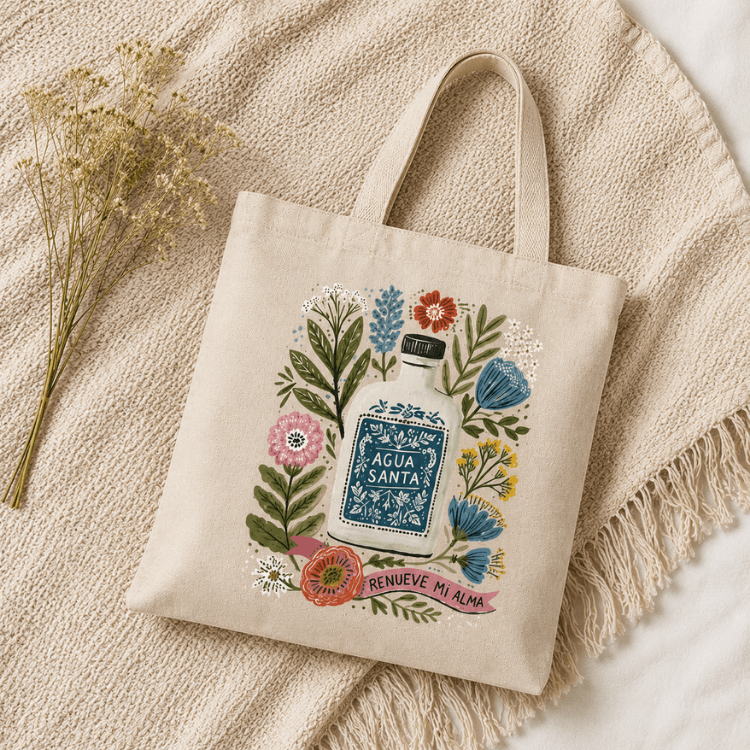 Agua Santa Canvas Tote Bag flat lay image with natural color blanket, Holy Smoak Studios wholesale faith-based retail product